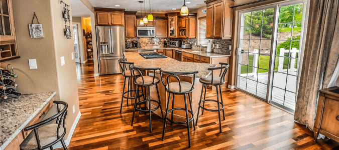 A kitchen with hardwood floors and wooden cabinets