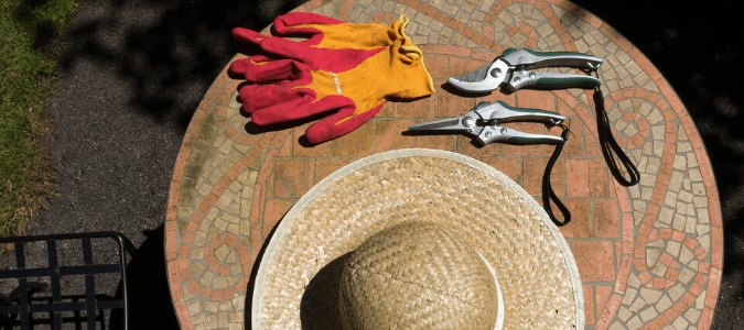 a hat, gardening shears and gloves to get started with spring landscaping cleanup