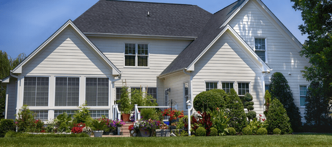 A backyard with shrubbery and flowers