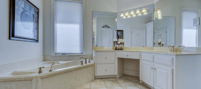 A cream colored bathroom that is suffering from signs of hard water