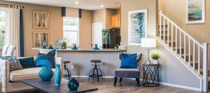 A gray living room next to a kitchen