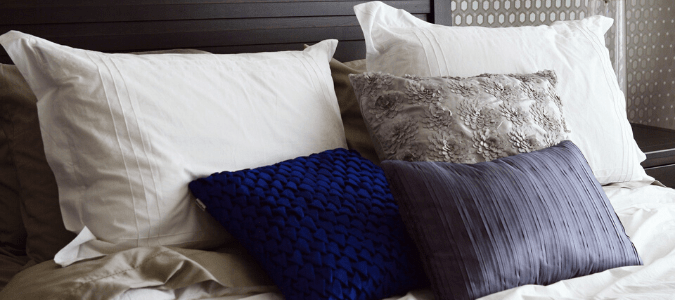 Decorative pillows on a gray bed