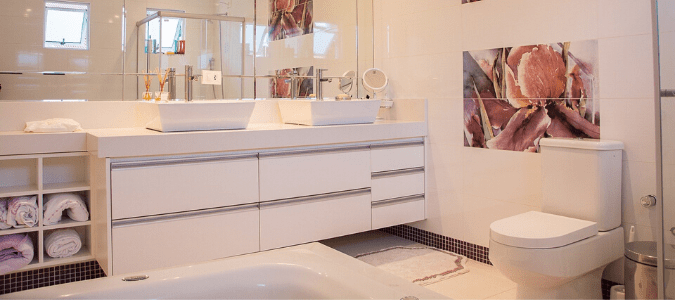 A bathroom with a white toilet and white cabinets