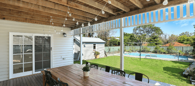 A backyard with an outdoor dining area and pool