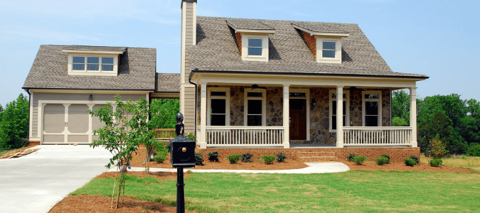 The front yard of a home with brown patches due to malfunctioning sprinklers