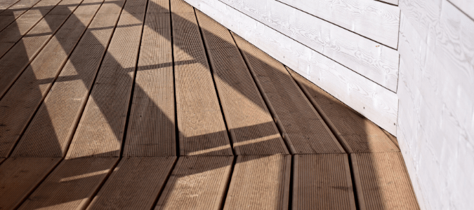 A white home with a wood deck that has been power washed