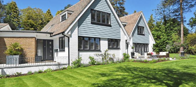 A white and blue home with cleaned gutters