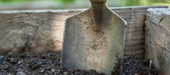 Someone turning over their compost to help organic matter decompose
