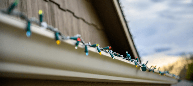 Christmas lights attached to gutters with plastic clips