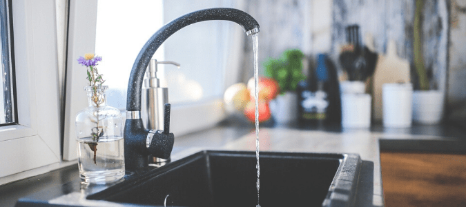 a black kitchen sink that is running