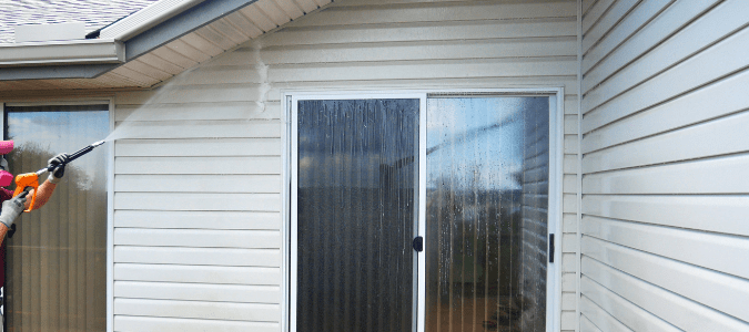 a homeowner pressure washing their home