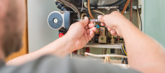 a technician fixing a furnace