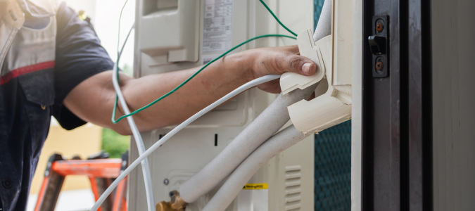 an HVAC technician working on an AC unit
