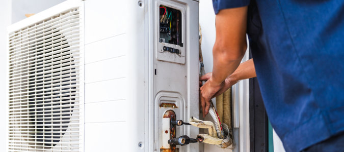 a technician working on an AC unit